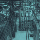 Industrielle Produktionshalle mit großen Edelstahltanks, komplexen Rohrleitungen und Maschinen von oben.